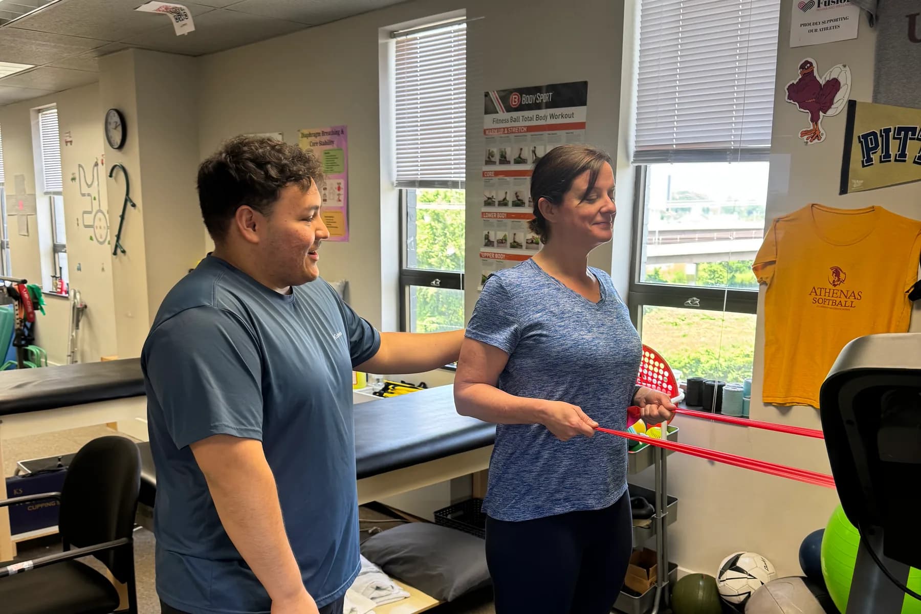 Two people work through a resistance-band exercise in the Alexandria clinic.