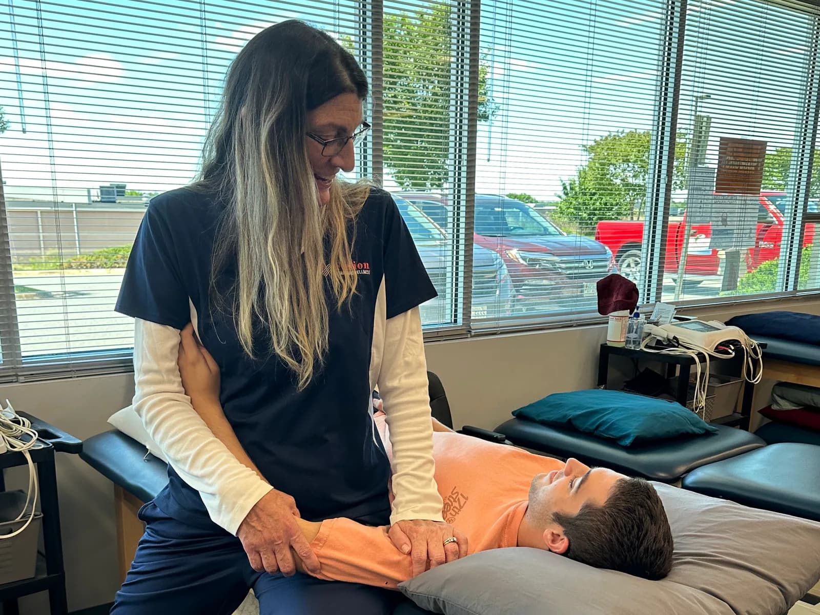 Hands-on guidance of an arm movement on a treatment table.