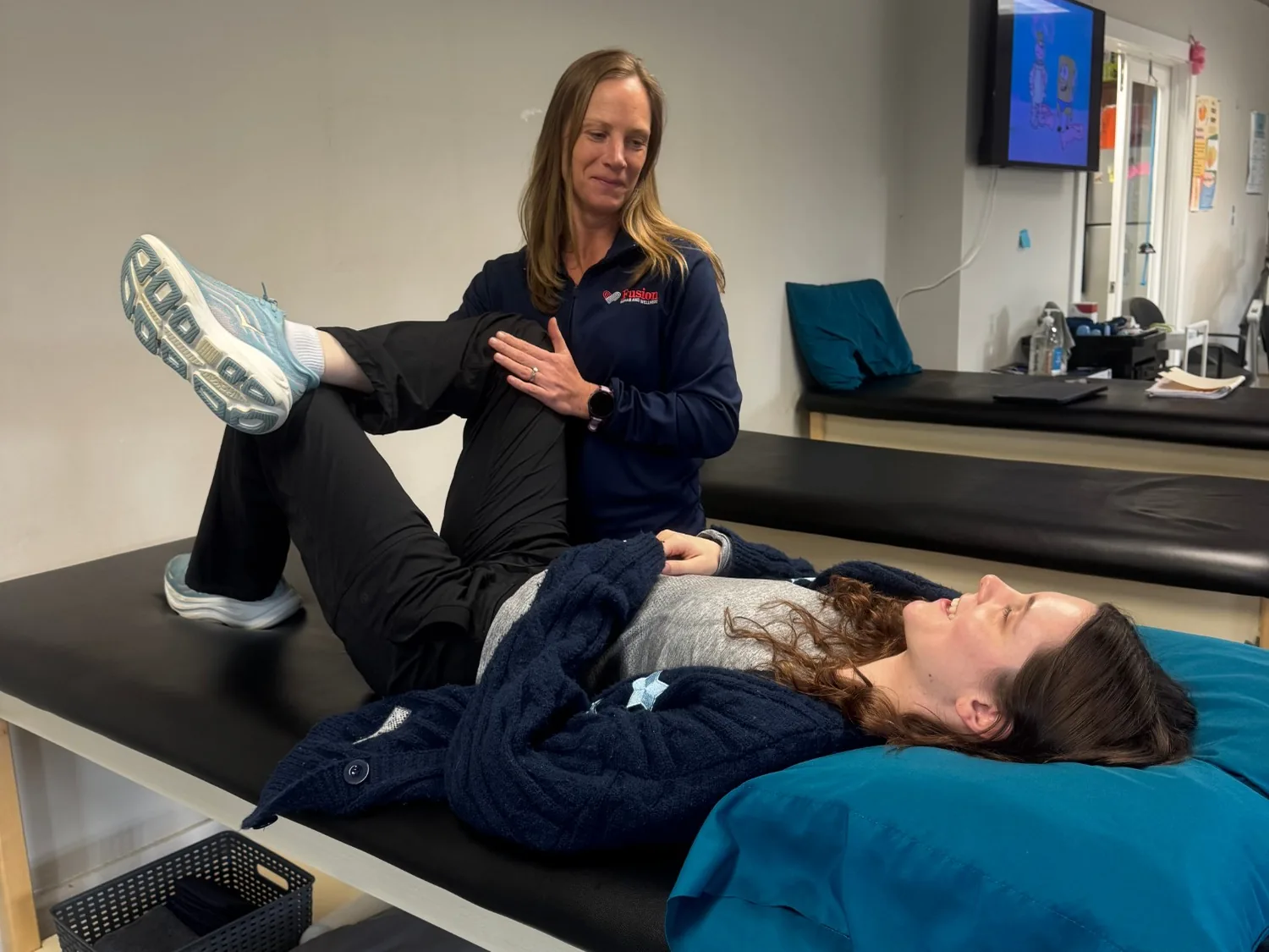 Guided bent-knee leg movement on a treatment table.