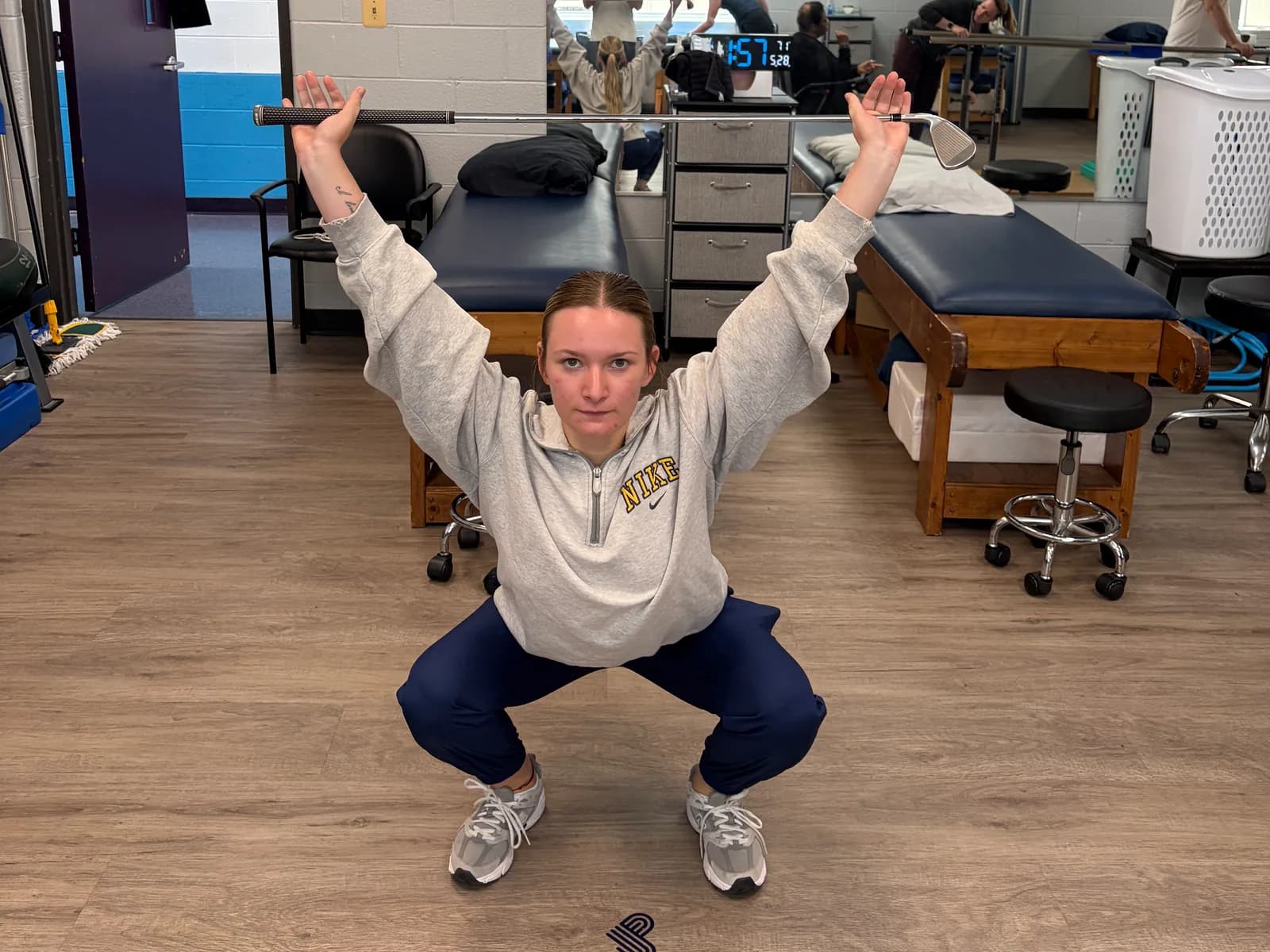 Overhead squat movement screening with a golf club.